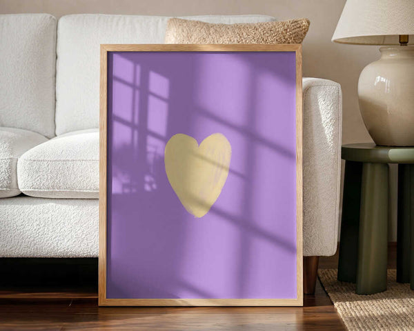 Framed Gentle Yellow Heart nursery print displayed in a minimalist baby room.