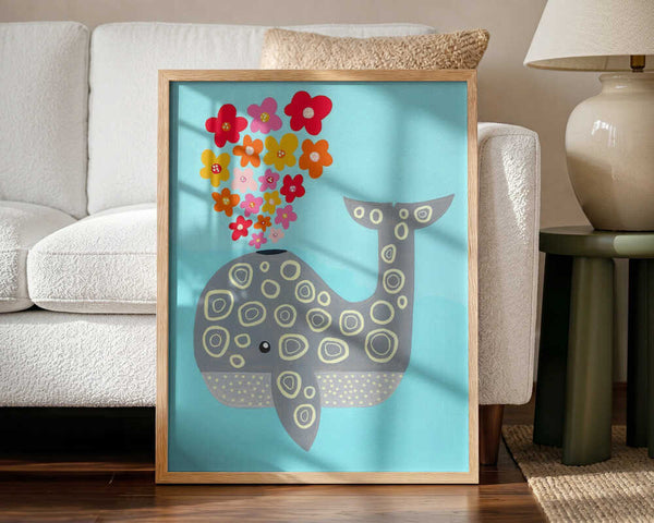 Framed Floral Spouting Whale ocean nursery print displayed in a pastel baby room.